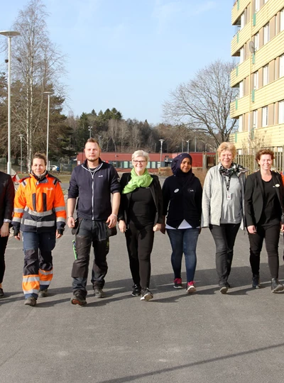 Eidar kollegor i bredd på en väg framför ett höghus