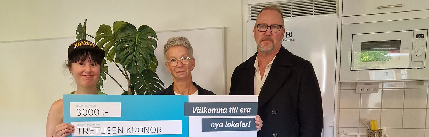 Vid invigningen tog Viola Juric, enhetschef för Slättbergsvägen 180 och Johanna Johansson, en av de boende, emot ett presentkort i stort format från Hans-Åke Erlandsson, Eidars projektledare för renoveringen och anpassningen av lokalerna.