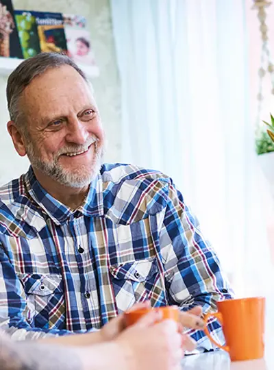 Hyresgäster hos Eidar, man och kvinna fikar vid köksbord