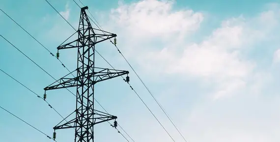 En kraftledning syns mot en blå himmel