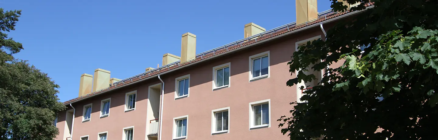 Fasadbild av Flottberget i Trollhättan centrum. Rosa fasad mot blå himmel
